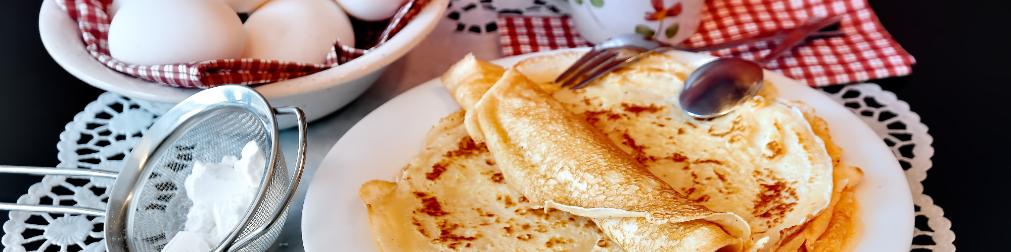 Freshly baked pancakes with syrup and icing sugar